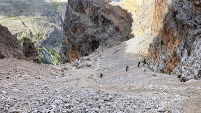 La ripida discesa attraverso il burrone carico di massi fino al lago di Lagazuoi richiede un passo sicuro