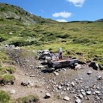 Am Wegesrand verheißt ein Brunnen eine willkommene Erfrischung