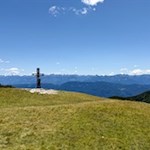Gipfelkreuz des Roen vor malerischer Kulisse