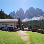 In front of the backdrop of the Geisler peaks the Dusler Alm mountain hut invites to table