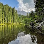 Die Felsspitzen des Latemar spiegeln sich im Mittersee