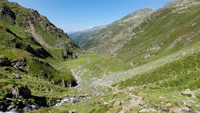 Die junge Ahr ergießt sich über die sattgrünen Almböden