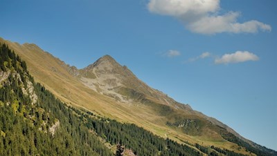 Der Weg wird von einsamen Bergspitzen umrahmt