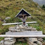 Wegkreuz mit Rastbank auf dem Weg zur Tribulaunhütte