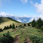 Rückwärtsgewandter Blick auf die ersten Anstiegsmeter auf dem Grasrücken und den kreuzgeschmückten Salzla