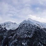Der winterliche Wald gibt immer wieder Blicke auf die gegenüberliegende Bergwelt frei