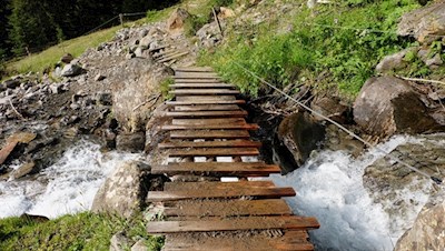Ein Holzbrücklein geleitet sicheren Fußes über den Bach