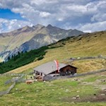 Die Genterer Alm wird von Wiesen und Bergen umrahmt