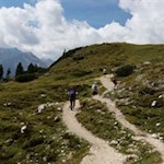 In the upper part, the hiking trail winds through mountain meadows with great views