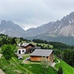Die-Schatzerhütte-vor-der-idyllischen-Kulisse-des-Peitlerkofel-und-der-Aferer-Geisler