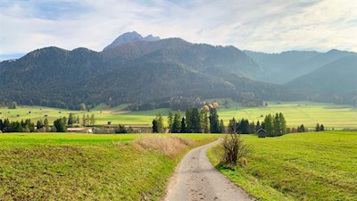 Der Lanerweg führt durch bergumrahmte Wiesen und Felder