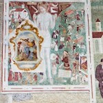 Religiöse Fresken zieren die Außenwände des Kirchleins