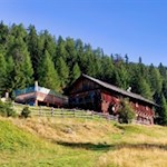 Inmitten einer waldumsäumten Lichtung lädt die Pertinger Alm zur Einkehr