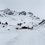 Against the backdrop of a mountain landscape covered in deep snow presents the Knuttenalm mountain hut