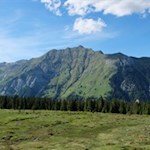 Die Wanderung zu den Wumblsalmen führt durch offene, von hohen Felswänden umrahmte Almlandschaften