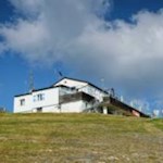 Die Plosehütte auf rund 2450 m hebt sich vor dem herbstblauen Himmel ab