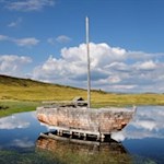 Auf einem der Glittner Seen gleitet ein Holzschiff