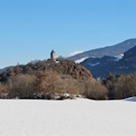 Die St. Verena Kirche thront auf einem bewaldeten Porphyrhügel