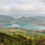 Blick auf den von herbstbunten Obstwiesen umrahmten Kalterer See