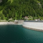 Die imposante Bogenmauer des Neves-Stausees