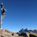 Das monumentale Gipfelkreuz der Außerraschötz mit den Villnösser Geislern im Hintergrund