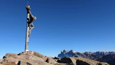 Das monumentale Gipfelkreuz der Außerraschötz mit den Villnösser Geislern im Hintergrund