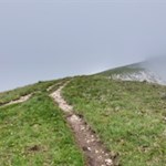 Über einen Grashang auf den Gipfel