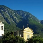 La chiesa di Santo Stefano di fronte alle imponenti pendici del Monte Baldo