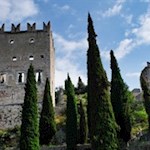 Zahlreiche Zypressen umsäumen die wehrhafte Feste