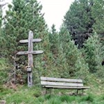 Neben einem Wetterkreuz lädt eine Aussichtsbank zum Verweilen ein