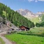 Die Huberalm vor der Kulisse der dahinter aufragenden Bergwelt