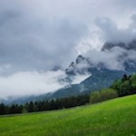 Im Hintergrund ragt der wolkenumrankte Schlern in die Höhe