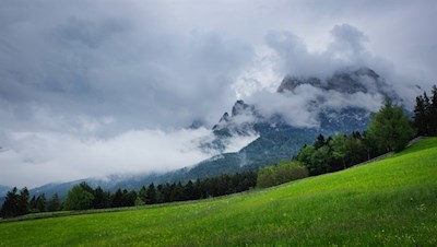 Im Hintergrund ragt der wolkenumrankte Schlern in die Höhe