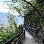 Eng an die Felswände geschmiegt führt eine Holzbrücke über eine ausgesetzte Stelle