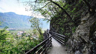 Eng an die Felswände geschmiegt führt eine Holzbrücke über eine ausgesetzte Stelle