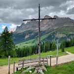 Das schlichte Holzkreuz der Latemarwiesen vor der Kulisse des Rosengarten