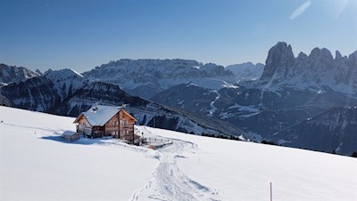 Die idyllisch gelegene Raschötzhütte mit Blick auf den Sellastock und den Langkofel
