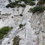 Addossato alle rocce, lo stretto sentiero si snoda sul Monte Piano