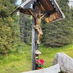 Cross with bench on the way to Ciavaz moutain hut