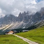 Rifugio-Brogles-mountain-hut-with-the-Odle-peaks-towering-behind-it