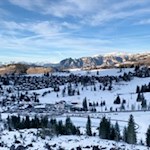 Unser Blick fällt auf die Siedlung Karersee und die dahinter aufstrebende Bergwelt