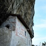 Die Einsiedelei "Eremo di San Paolo" zu Füßen eines überhängenden Felsens 