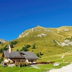 Gampenalm mountain hut in front of the backdrop of Zendleser Kofel (Col di Poma)