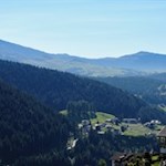 In der Ferne zeichnen sich die Silhouetten der Rosszähne und des Schlern ab