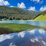 Die Wolken spiegeln sich in den klaren Wassern des Durnholzer Sees