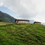 Auf einem sonnenbeschienenen Hang thront die Stegeralm 