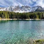 Lake Carezza is surrounded by spruces and the Latemar