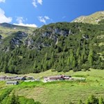 Inmitten grüner, von schroffen Felsen umrahmter Wiesen präsentiert sich die Vallmingalm