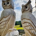 Holzgeschnitzte Eulen wachen über den Teich der Saraghes Hütte