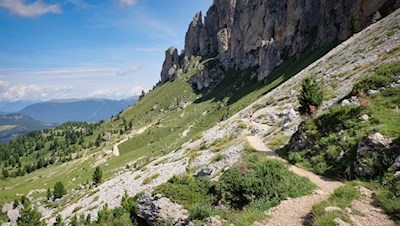 The hiking trail no. 527 winds through the picturesque landscape at the foot of the Sassolungo group